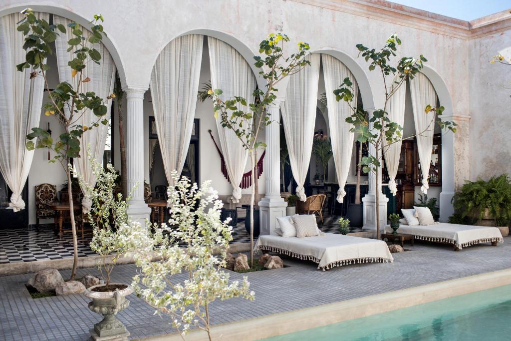 梅里达Casa Olivia的酒店大堂设有两张床和一个游泳池