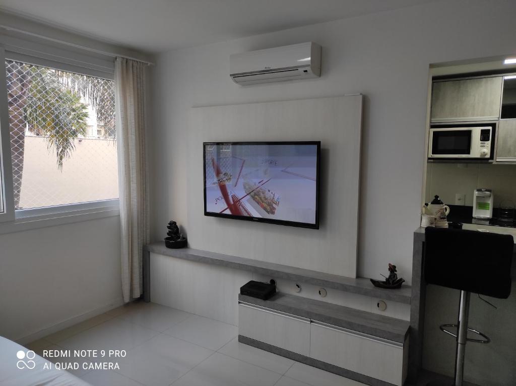 卡诺阿斯Lindo apartamento ao lado do Park Shopping Canoas的客厅的墙上配有平面电视。