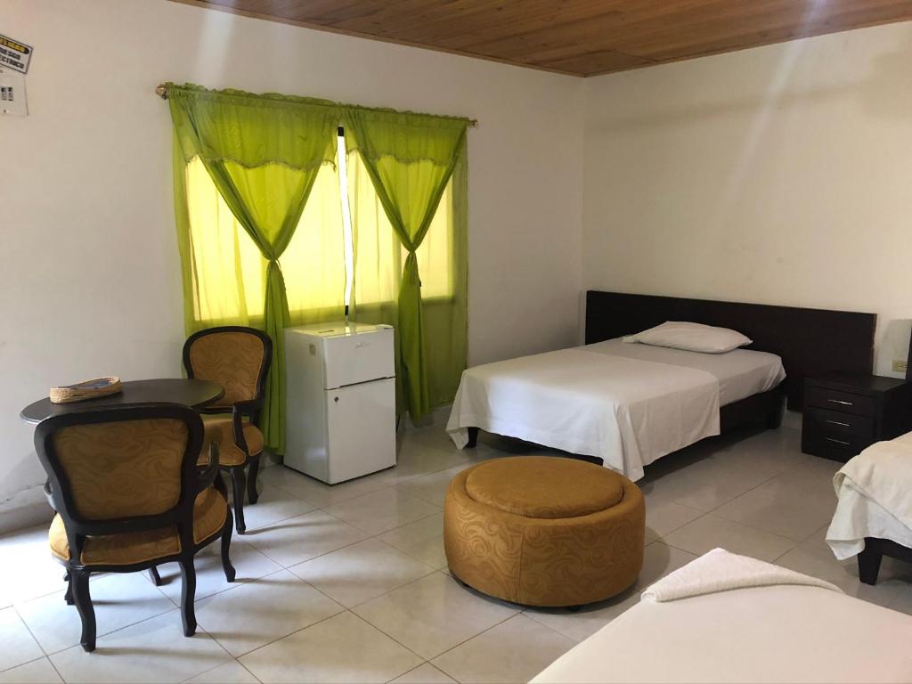 Hotel El Lago的一间设有两张床和一张桌子及椅子的房间