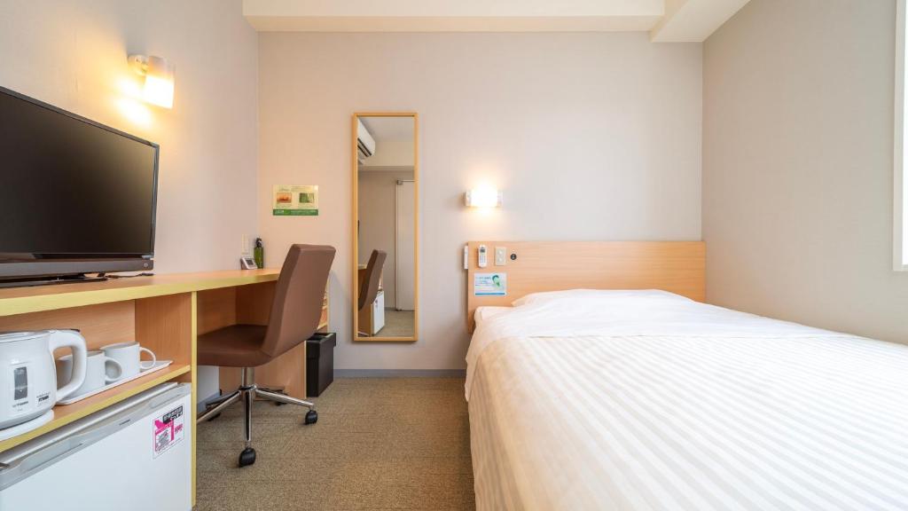 东京野御徒町超级酒店的酒店客房配有一张床和一张书桌及一台电视