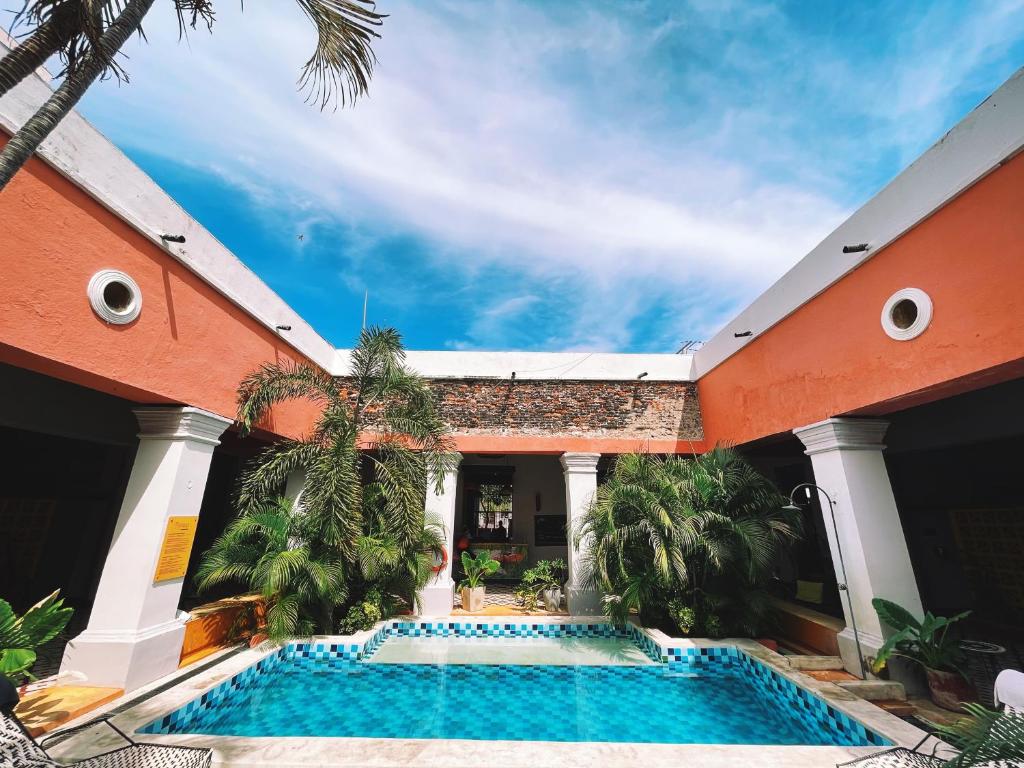 圣玛尔塔República Bahía Santa Marta Hostel的一座带房子的建筑的庭院中的游泳池