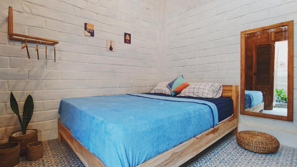 卡里蒙贾瓦KALINDA HOMEY的一间卧室配有一张带蓝色床单和镜子的床