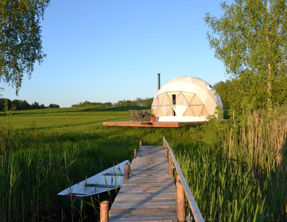 IzvaltaGlempings Velo Latgale的通往田野圆顶帐篷的木板路