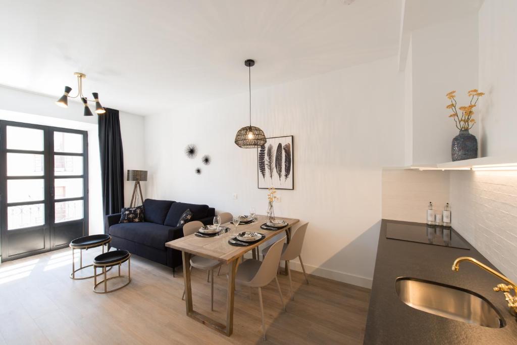 希洪Santa Catalina Suites Gijón的客厅配有桌子和蓝色沙发