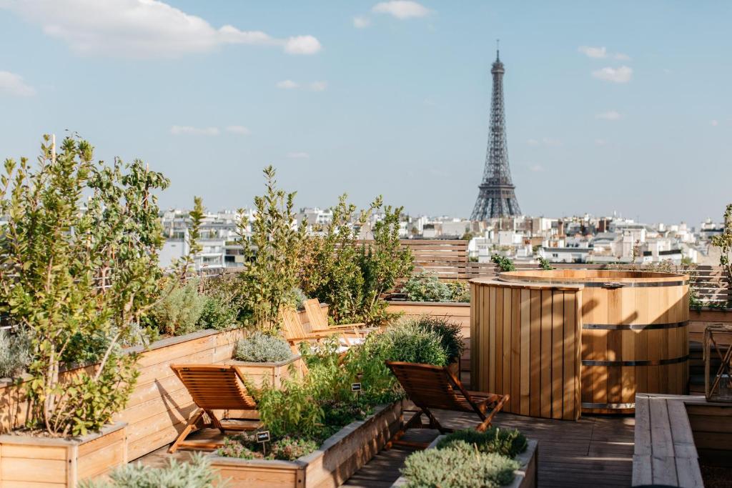 巴黎Brach Paris - Evok Collection的屋顶花园设有椅子和艾菲尔铁塔