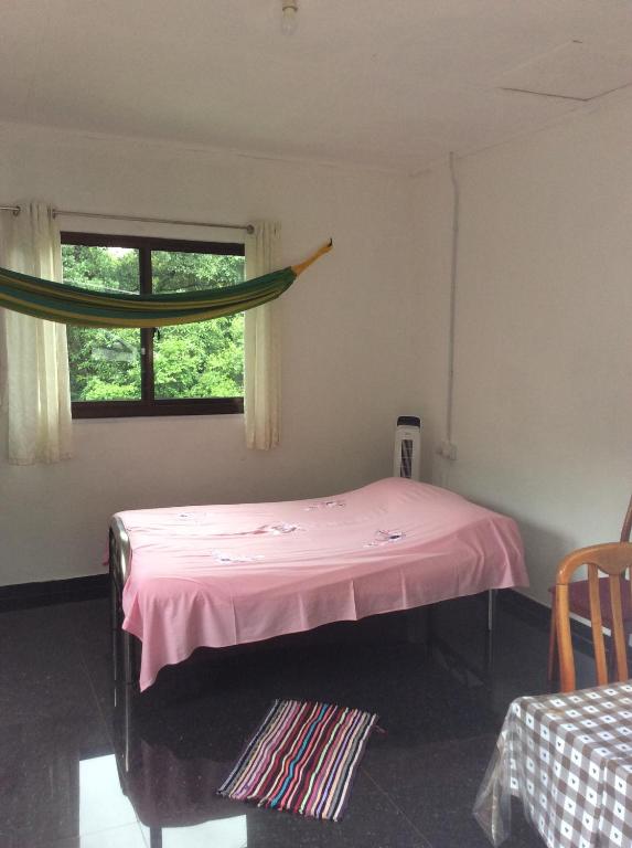维多利亚PAPAYAS SELF catering ROOM的卧室配有粉红色的床和窗户。
