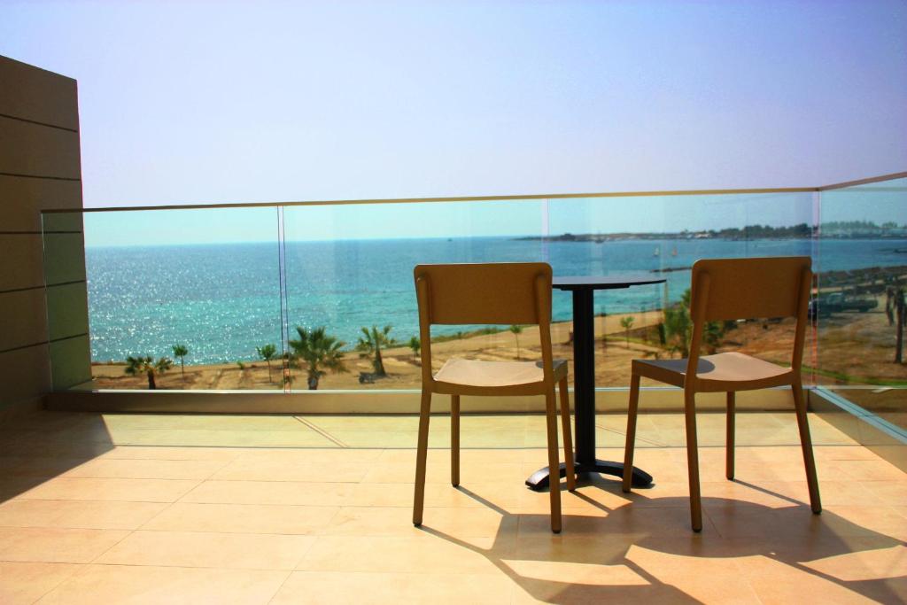 帕福斯Gold Lagoon Kosher Hotel的海景客房中的一张桌子和两把椅子