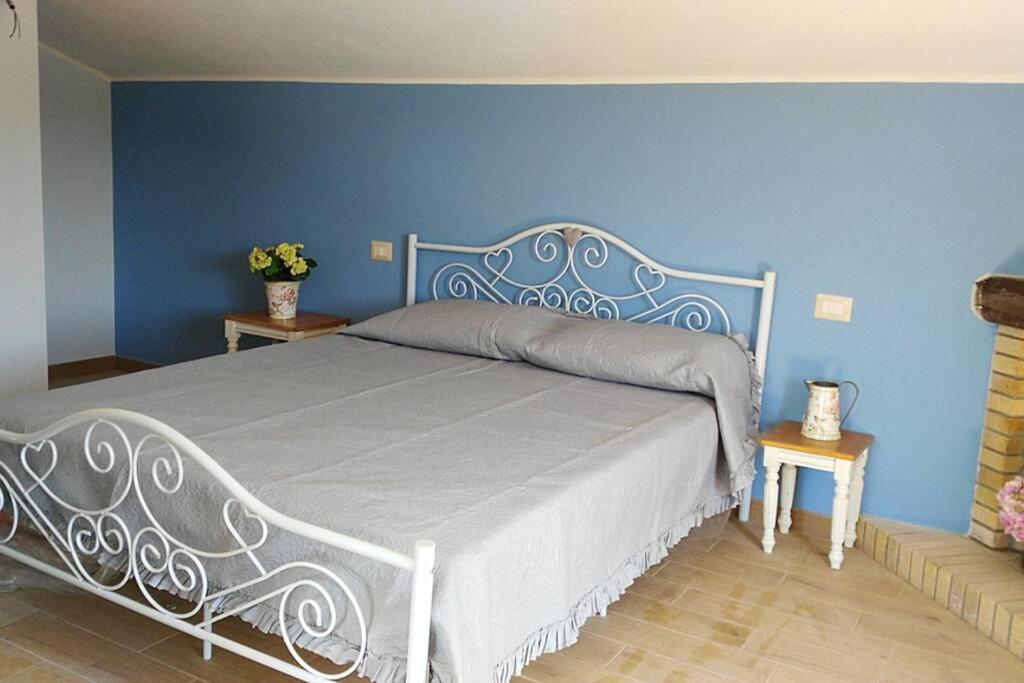 SeùloFERULA romantica mansarda tra fiumi e montagne Sardegna的卧室内的一张床铺,卧室内有蓝色的墙壁