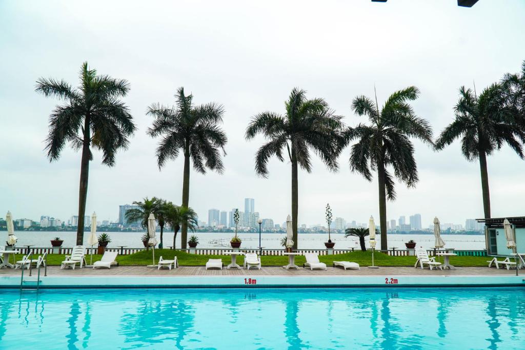 河内Thang Loi Hotel的一座棕榈树环绕的游泳池