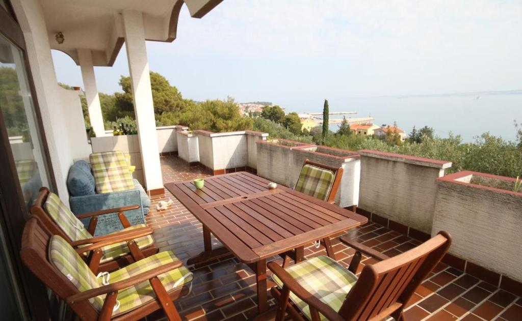 卡利Apartment in Kali with sea view, terrace, air conditioning, WiFi (4230-3)的阳台上的木桌和椅子