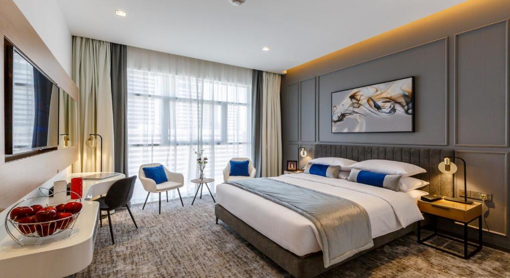 迪拜Rose Executive Hotel - DWTC的酒店客房,配有一张床、一张桌子和椅子