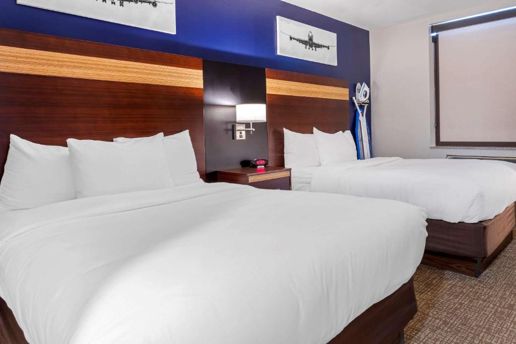皇后区Avion Inn Near LGA Airport, Ascend Hotel Collection的酒店客房设有两张床和窗户。