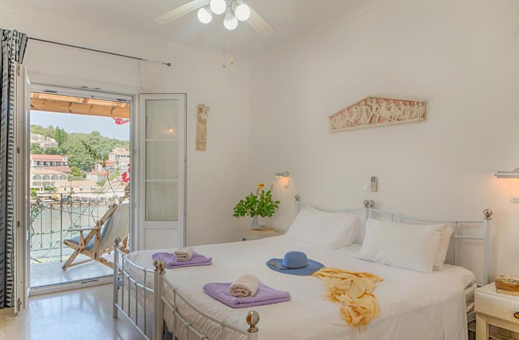 卡西奥皮MANESSIS Apartments Kassiopi Bay Corfu的一间卧室配有带毛巾的床和阳台