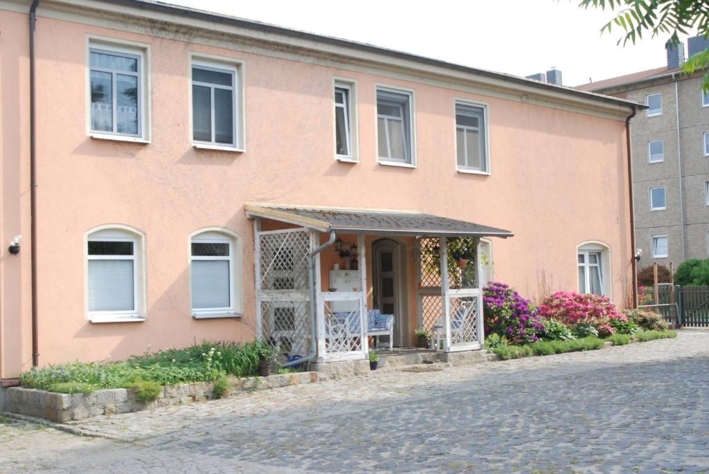 巴德马斯考Ferienwohnungen Stricker的粉红色的房子,有门和鲜花
