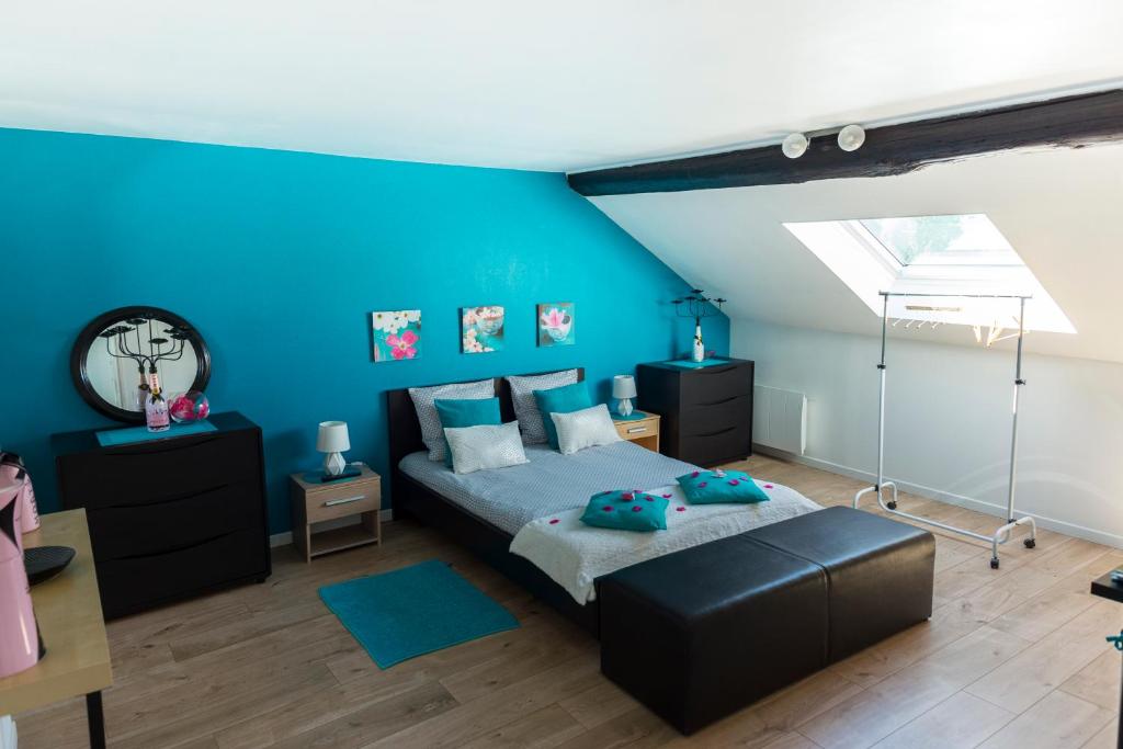 埃佩尔奈Escale à Épernay的一间卧室设有蓝色的墙壁、一张床和一张书桌