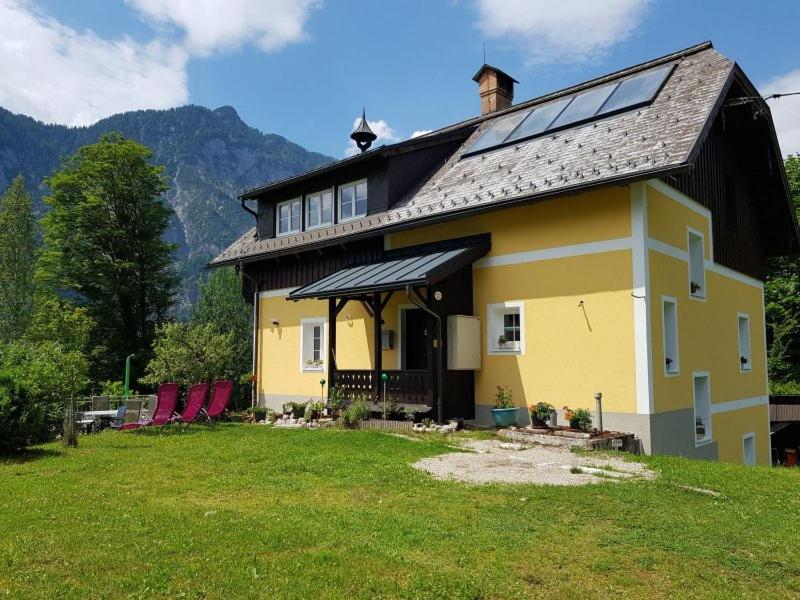 巴德哥依斯恩Ferienhaus Kopriwa的草坪上一座黄色房子,屋顶上设有太阳能屋顶