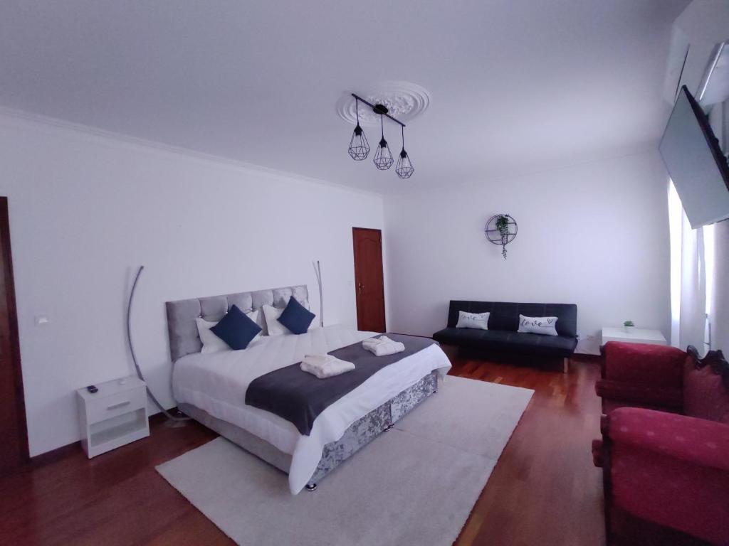 塔维拉Enchanted Villa的白色卧室设有一张大床和一张沙发