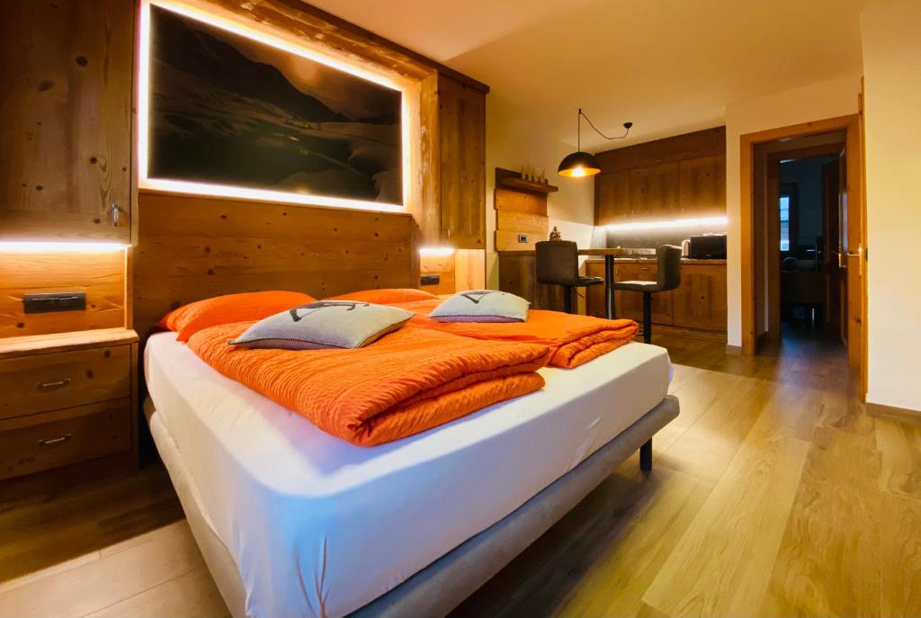 利维尼奥Chalet Nicolin的一间卧室配有一张带橙色毯子的大床