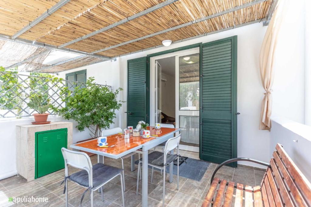 玛丽娜迪曼卡维萨Appartamento Violetta的一个带绿门和桌椅的庭院