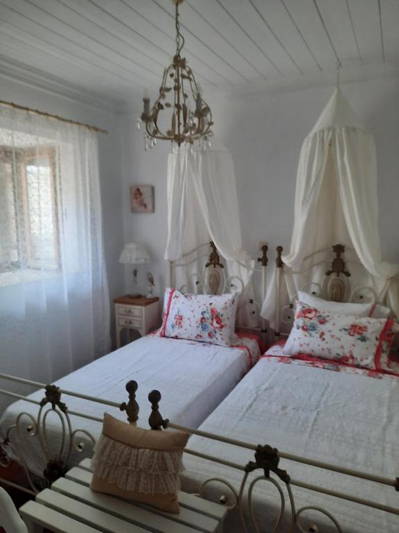Áyios PétrosCasa di Sofiana by wood and stone的一间卧室配有两张床和吊灯。