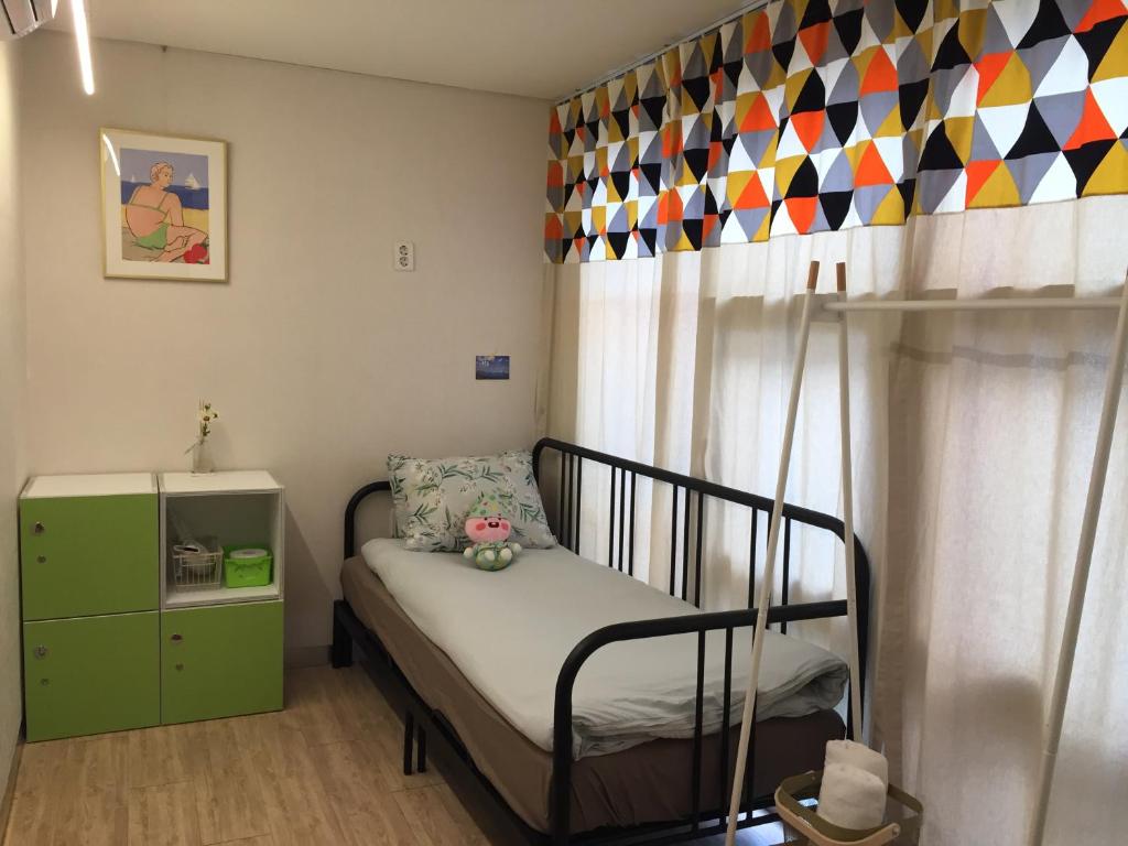 釜山釜山因塞德旅舍的一间小卧室,配有一张床和一个绿色的橱柜
