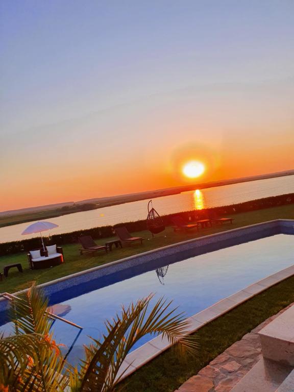 图尔恰Casa Miralago Boutique的一座享有日落美景的游泳池