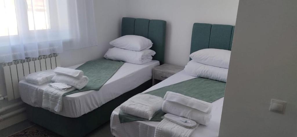 AksaySulo Aksai Hotel的小型客房 - 带两张单人床和毛巾