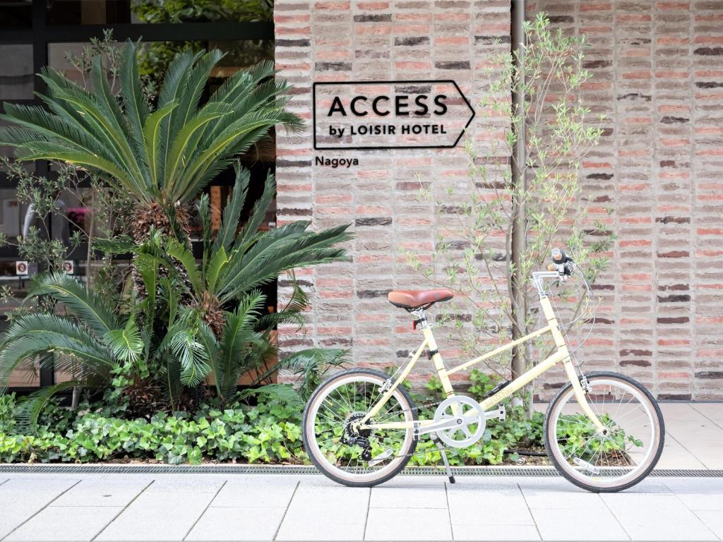 名古屋ACCESS by LOISIR HOTEL Nagoya的停在砖砌建筑旁边的一辆白色自行车