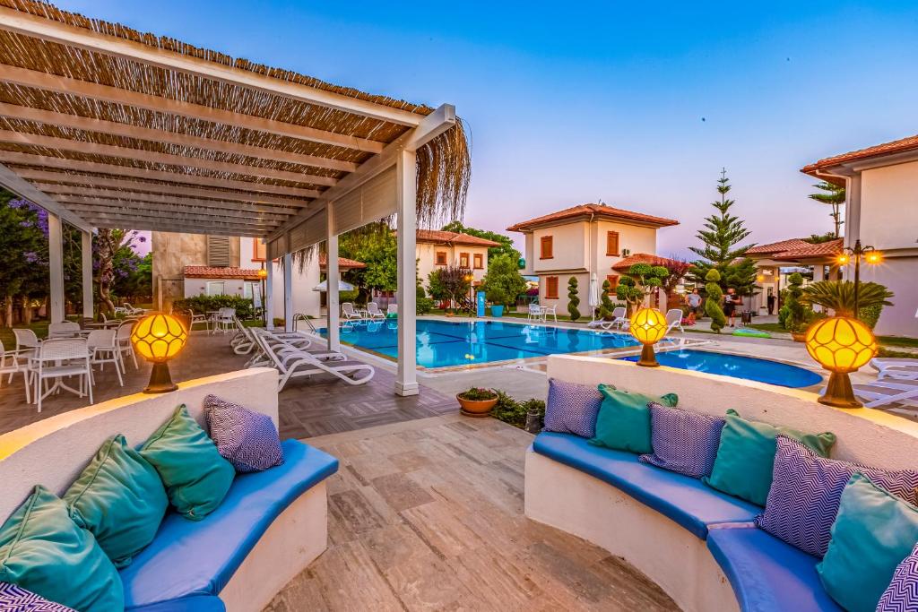 贝莱克Vista Villas的游泳池旁带蓝色和紫色枕头的天井