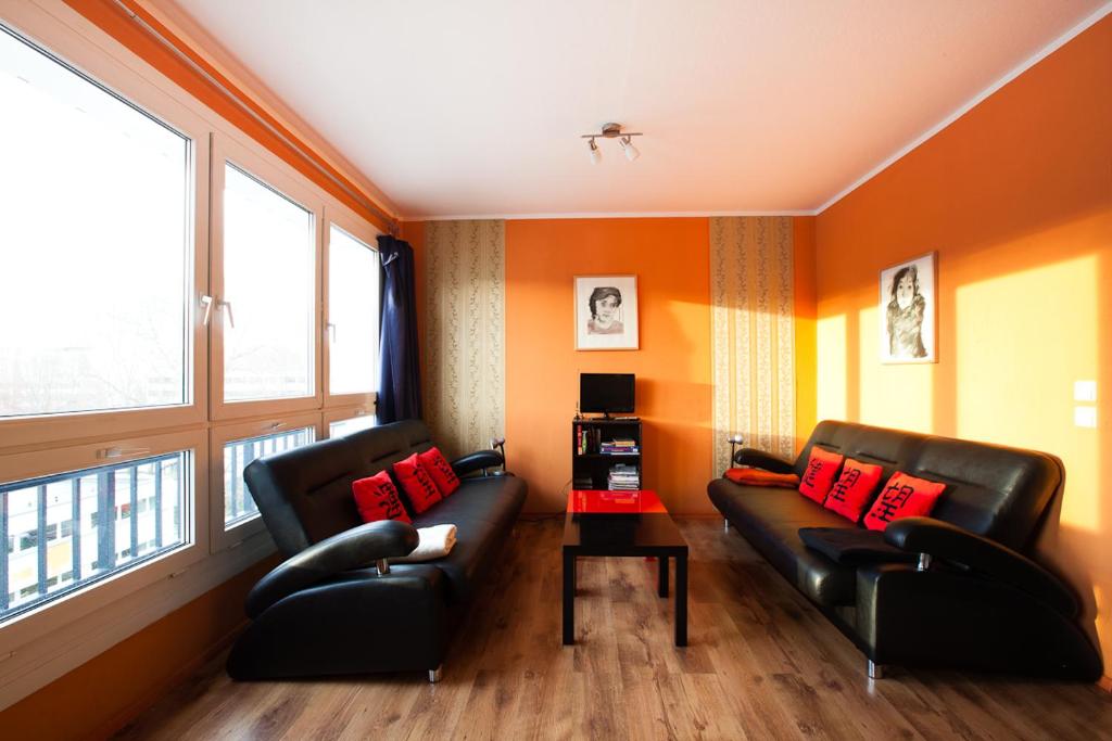 柏林公园及城市亚历克斯公寓的客厅配有2张黑色真皮沙发和2扇窗户