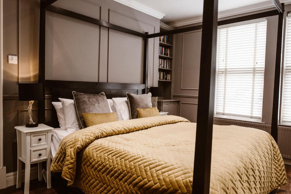 基尔肯尼Kilmore Guesthouse的一间卧室设有一张大床和一个书架