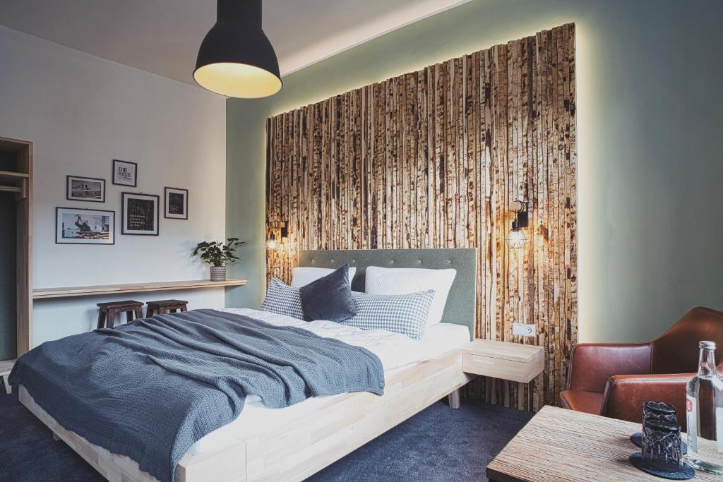 巴特明斯特艾弗尔Boutique Hotel LANDHAUSZEIT的一间卧室设有一张床和木墙