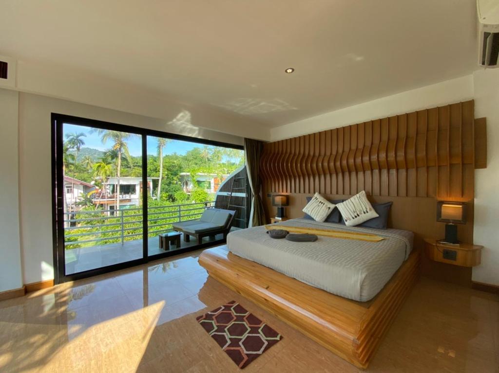 涛岛AC 2 Resort的一间卧室设有一张大床和一个大窗户
