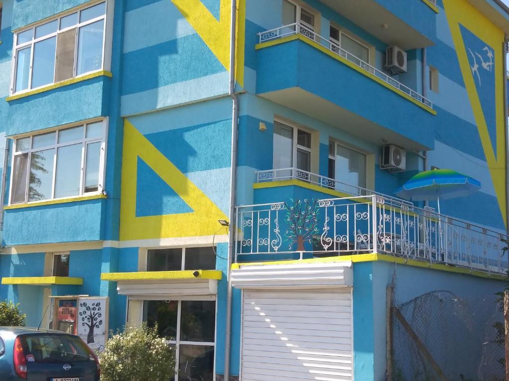 帕莫瑞Къща за гости Синьо Лято的蓝色和黄色的建筑,设有阳台