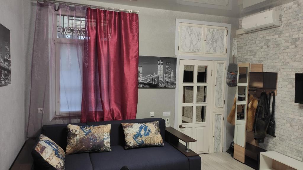 敖德萨Квартира на Дерибасовcкой的带沙发和红色窗帘的客厅