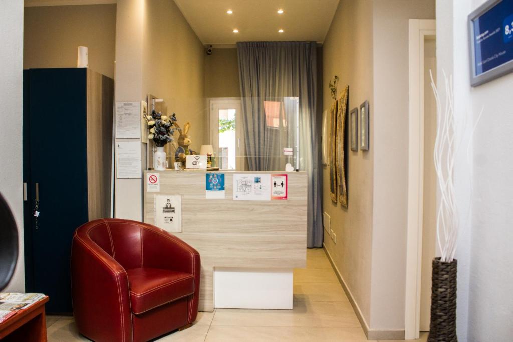 博洛尼亚圣奥索拉城市之家酒店的客厅配有红色椅子和柜台