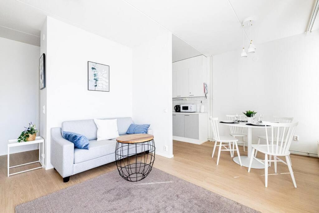 埃斯波Apartment Sleepwell, Leppävaara, 71m2 with private sauna的白色的客厅配有沙发和桌子