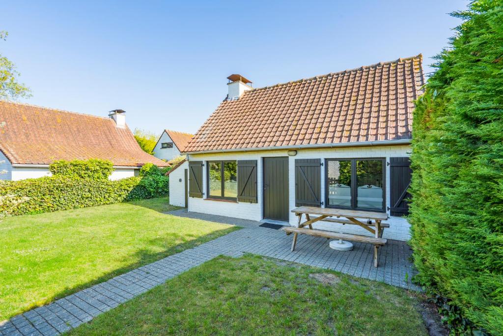 科克赛德Cottage 213 in Sunparks Oostduinkerke with free parking and garden的院子里带野餐桌的房子