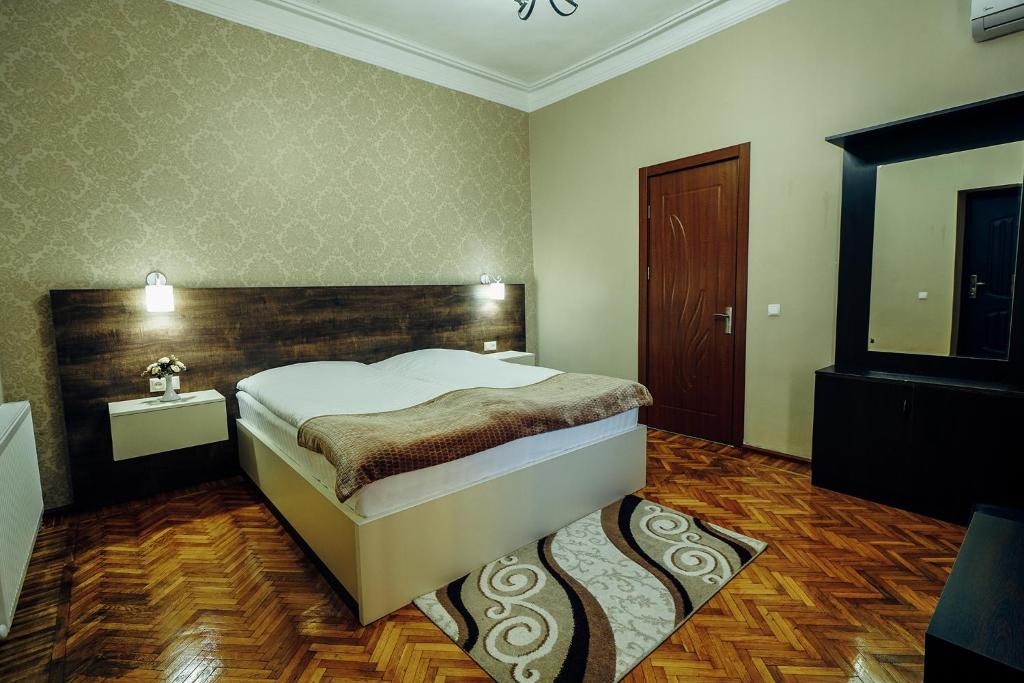 库塔伊西Hotel Eurica的一间卧室设有一张大床和一个木制床头板