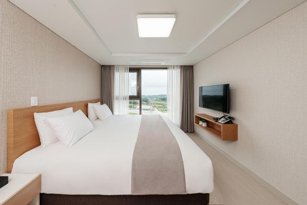 襄阳郡CENTUMMARK Hotel YangYang的酒店客房,配有床和电视