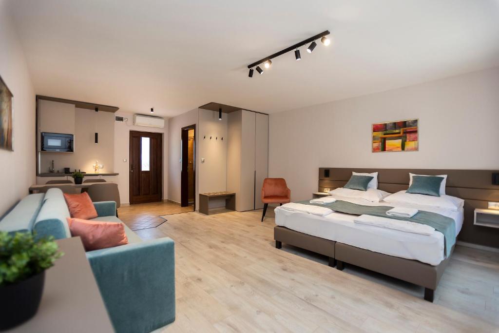 久洛Végvár Spa Apartman的一间带两张床和一张沙发的客厅