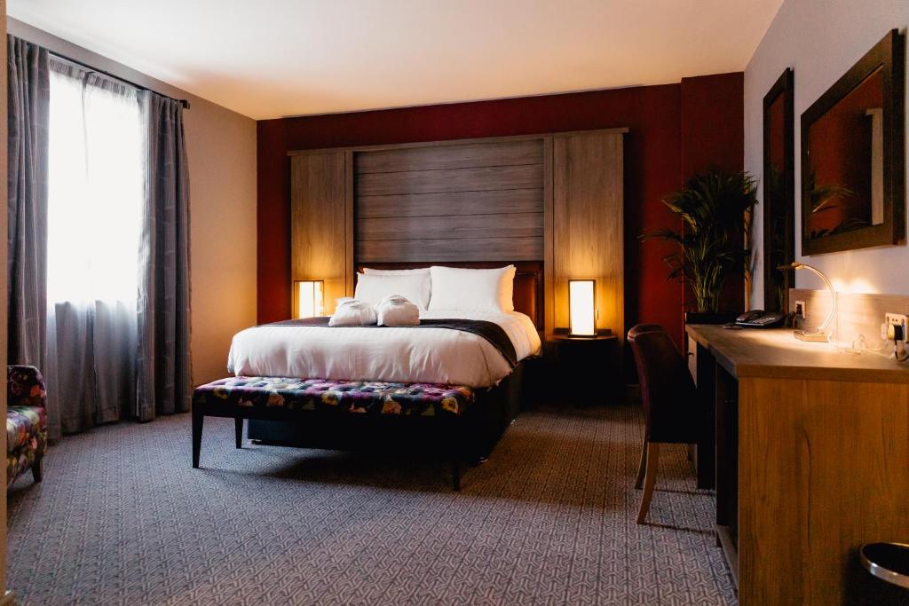 泰恩河畔纽卡斯尔Great North Hotel的一间卧室配有一张大床和木制床头板