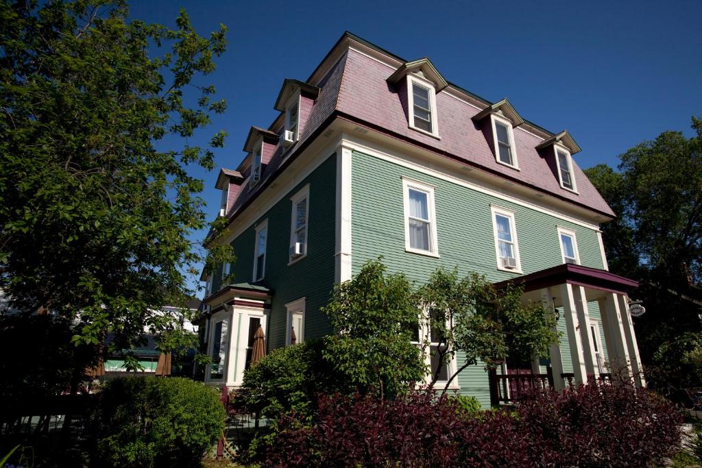 萨顿乐普勒贞特酒店和咖啡厅的一座带紫色屋顶的大型绿色房屋