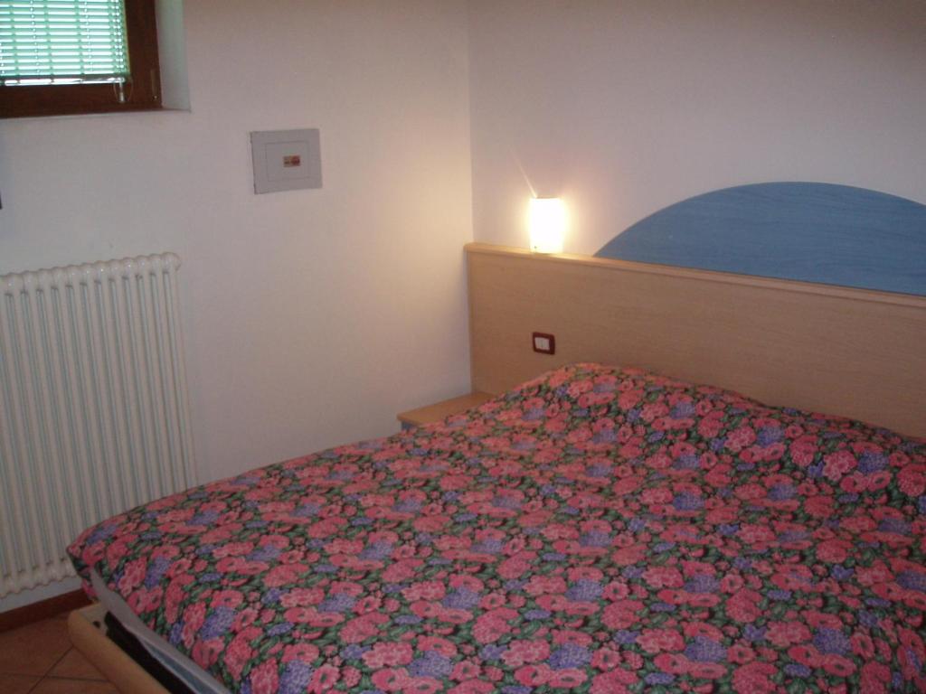 斯波尔马焦雷Casa Osti的一间卧室配有一张带花卉床罩的床