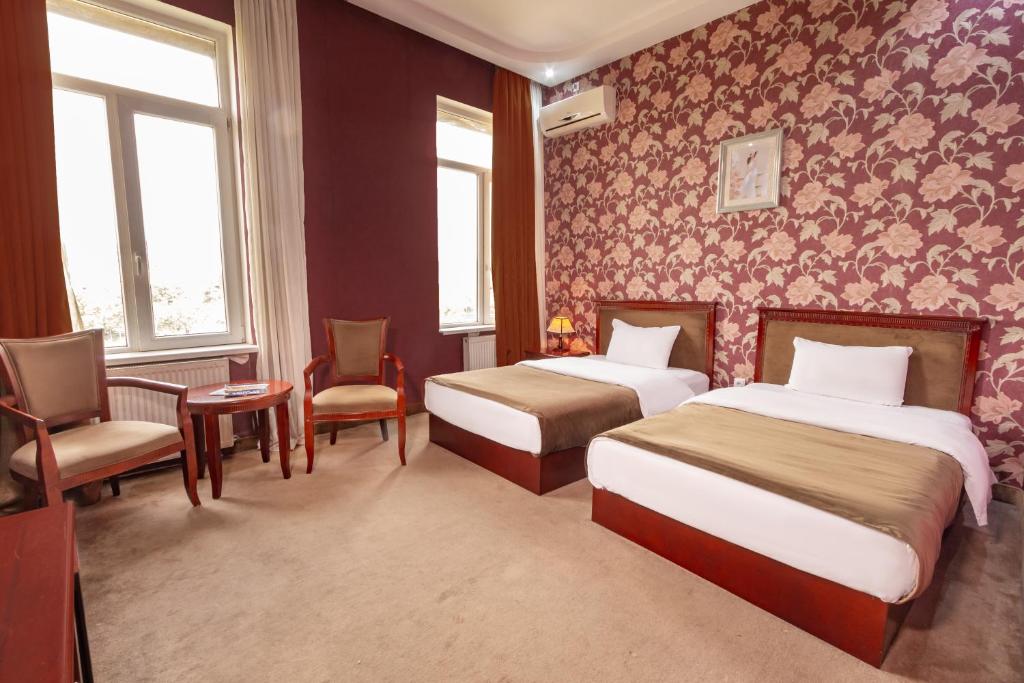 第比利斯马戈皇宫酒店的酒店客房,配有两张床和椅子