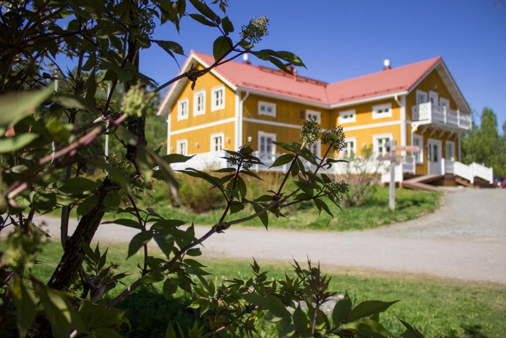 VuonislahtiHerranniemi Guesthouse的红色屋顶的大型黄色建筑