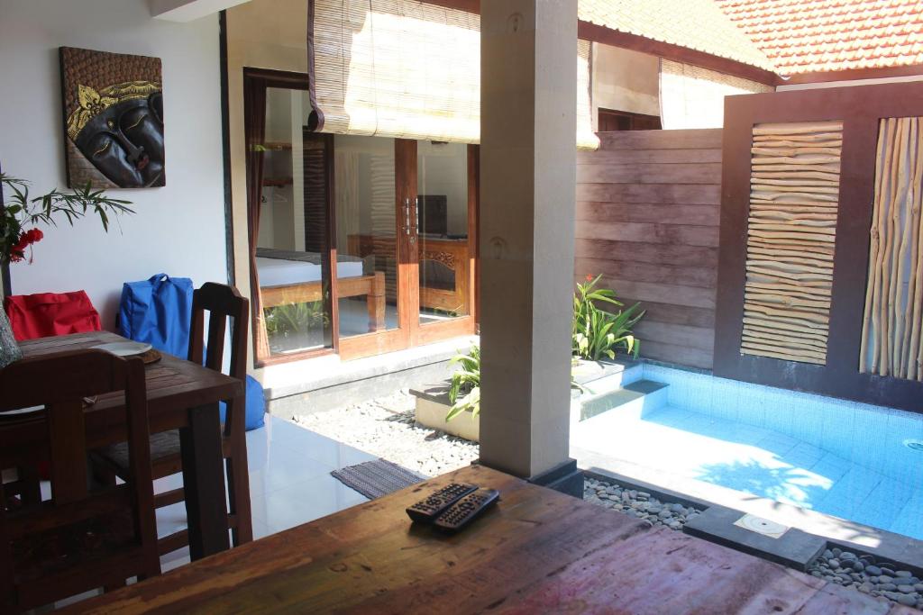 库塔Jukung Villas Kuta的客厅设有桌子和游泳池