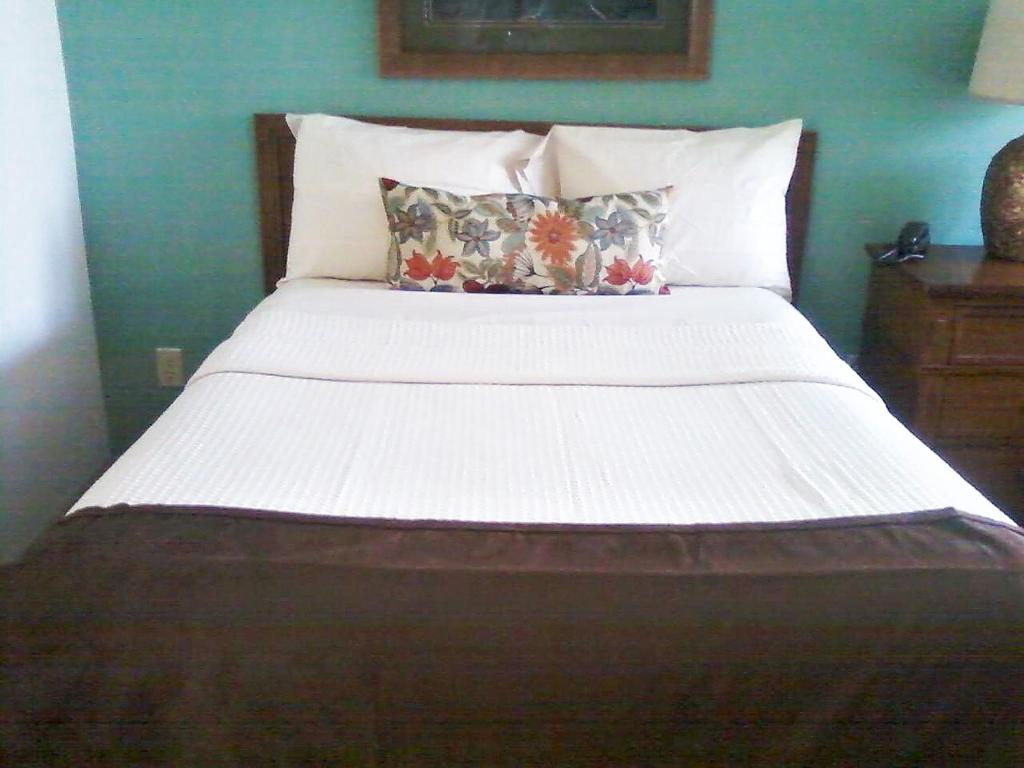 卢尔湖Fox Run Association, a VRI resort的卧室内的一张带白色床单和枕头的床