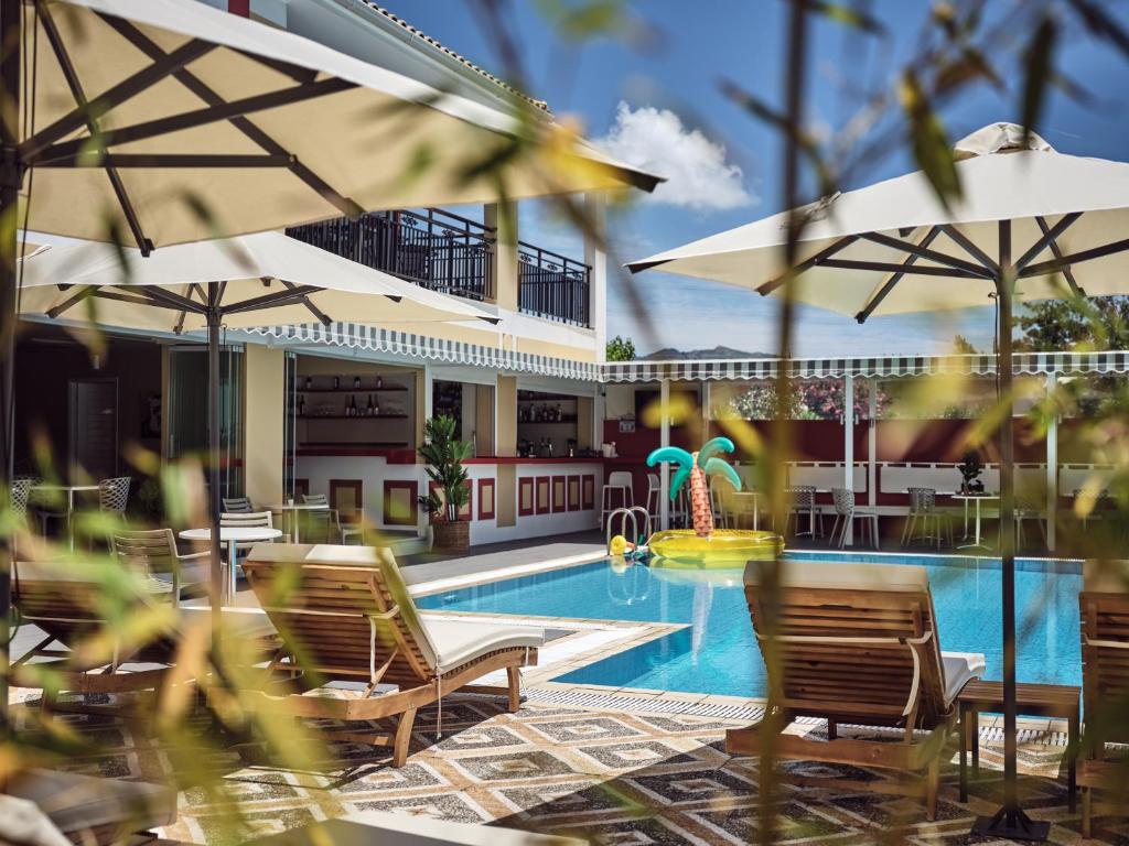 拉加纳斯仙人掌酒店的毗邻度假酒店的带椅子和遮阳伞的游泳池