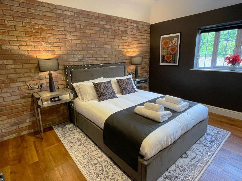 约维尔'The Loft'的一间卧室设有一张带砖墙的大床